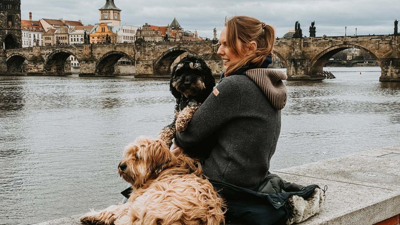 Frau mit Tibetterrier und Cockapoo an der Moldau vor Prag
